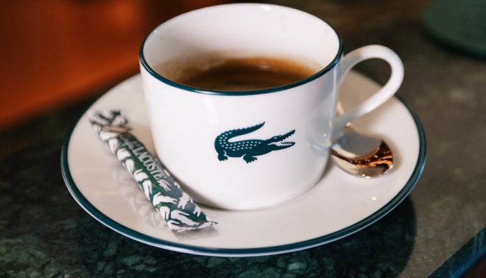 O Café Lacoste, inaugurado em Paris em 2026, é um exemplo da tendência de marcas transformarem lojas em experiências gastronômicas.